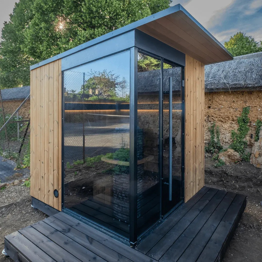 EDEN outdoor sauna installed in a walled garden, glass door and side window