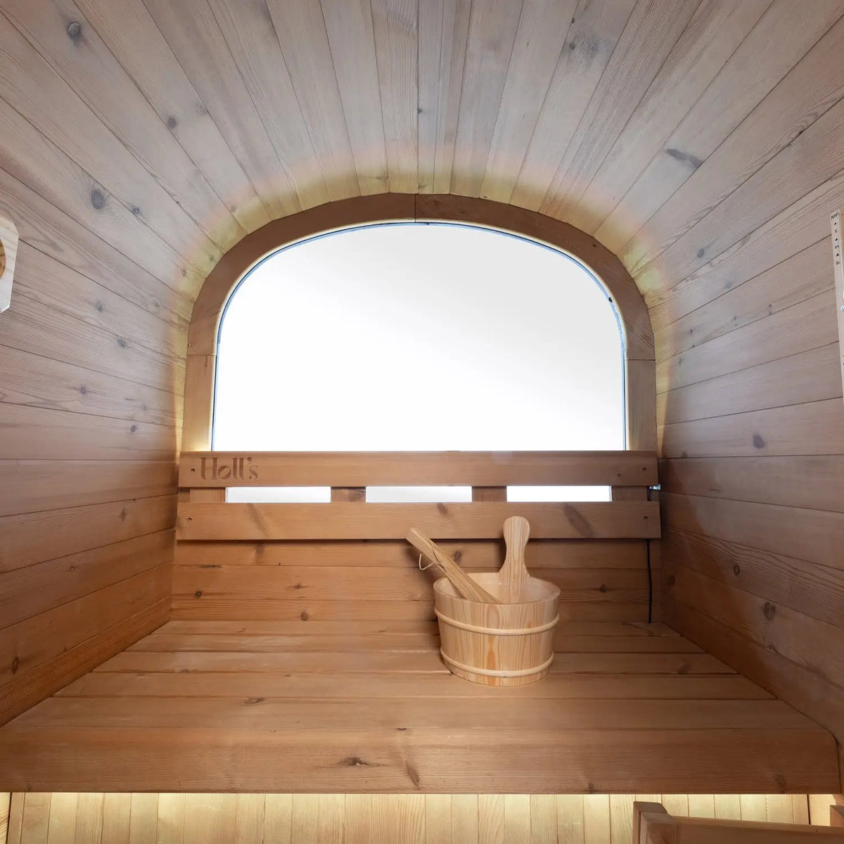 Holl's Cocoon 130 outdoor sauna interior with bench, bucket and porthole window