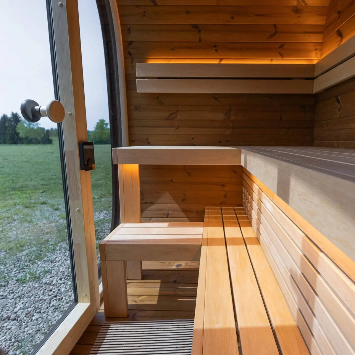 Holl's Onyxia Cube outdoor sauna interior with benches and glazed wall onto the garden