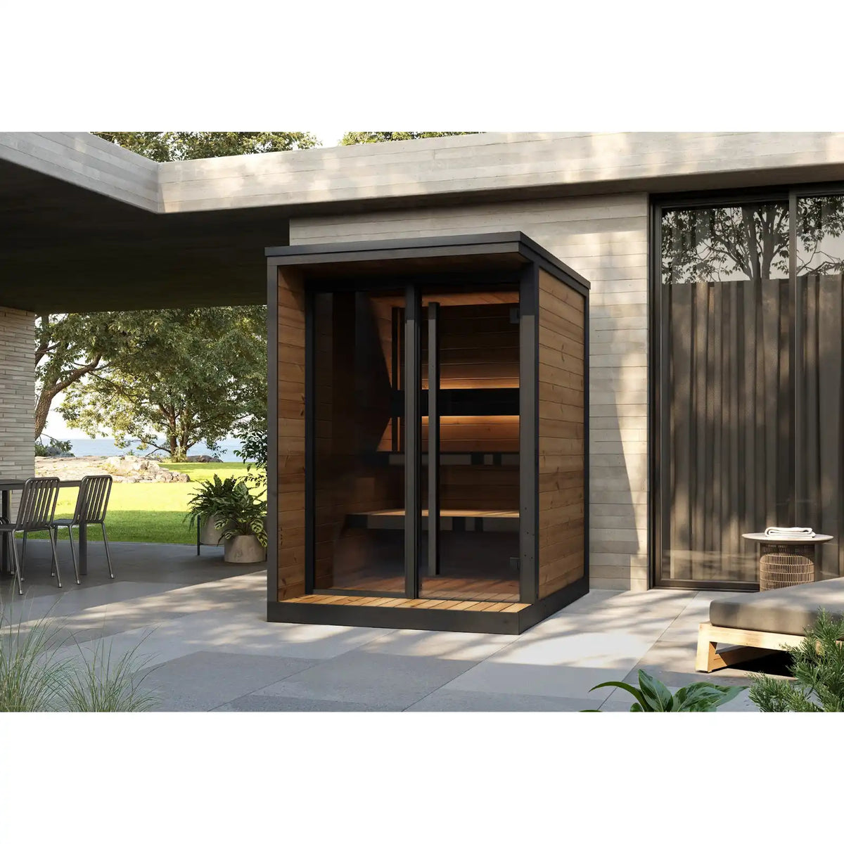 Hiki S sauna on a terrace beside a house, flat roof with black flashing, glass door open under the covered deck
