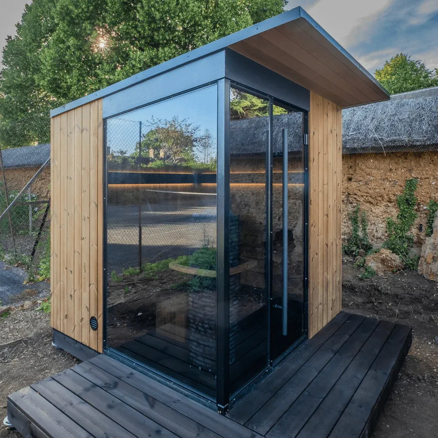 EDEN outdoor sauna installed in a walled garden, glass door and side window