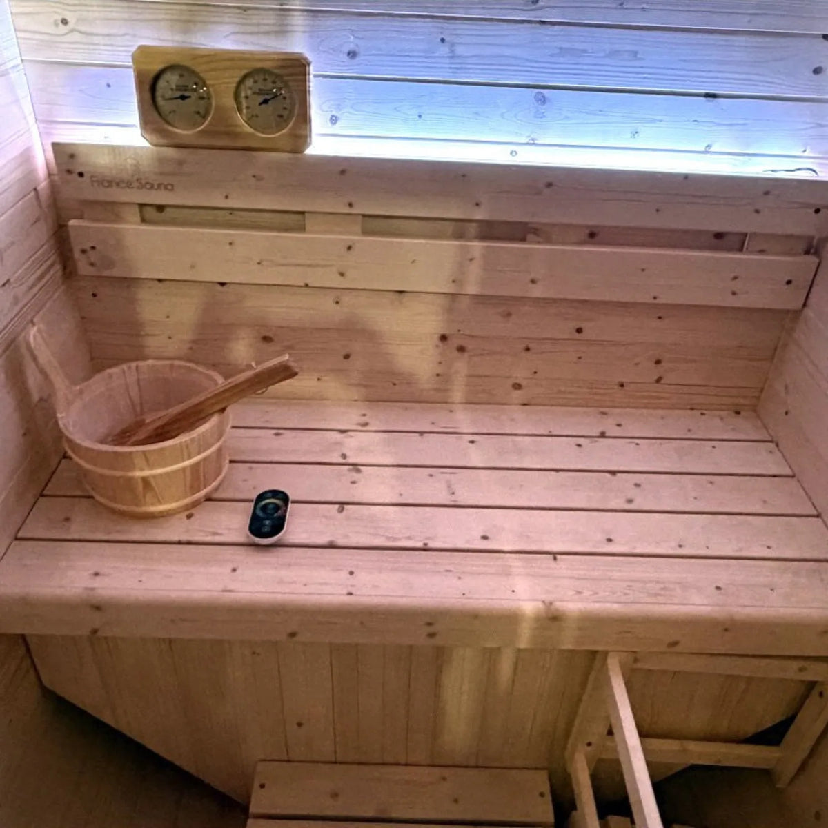 France Sauna Gaïa Urban outdoor sauna interior with bench, bucket and ladle