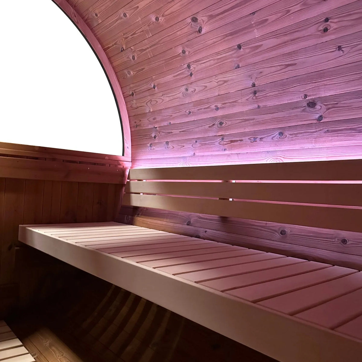 Holl's Onyxia Barrel outdoor sauna interior with pink LED lighting and porthole window