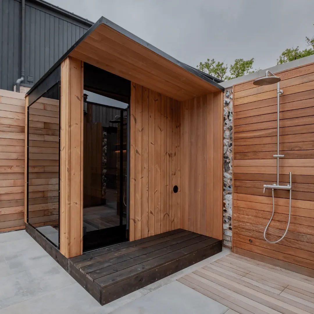 URSA outdoor sauna with its side overhang, installed beside an outdoor shower